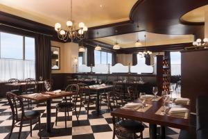 a restaurant with wooden tables and chairs and windows at Four Points by Sheraton Lagos in Lagos