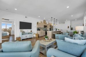 a living room with blue chairs and a kitchen at Professionally managed 1 block to beach Coffee in Seaside Heights
