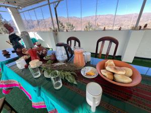 a table with a plate of bread and a bowl of food at hotel orkkowasi colca in Coporaque