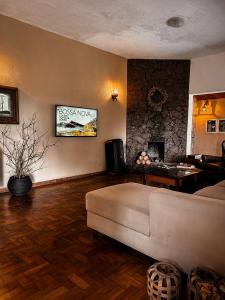 a living room with a couch and a table at Pousada Alto do Vale in Nova Friburgo