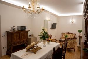 a dining room with a table and a chandelier at L'Alòz in Lugo