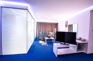 a living room with a flat screen tv in a room at Marshal Garden Hotel in Bucharest