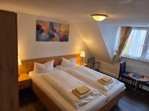 una camera da letto con un grande letto con due asciugamani sopra di Hotel Schatthaus a Greetsiel