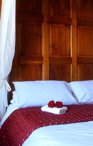 a bed with two red roses on top of it at The Griffin Hotel in Attleborough