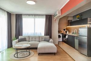 a living room with a couch and a kitchen at Ravda Bay Guest House in Ravda