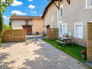 a backyard with a wooden fence and a picnic table at Duplex 2 chambres Meximieux centre ville in Meximieux