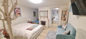 a bedroom with a bed and a couch and a fireplace at Alessandra‘s House in Arezzo