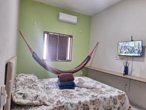 a bed with a teddy bear in a hammock in a room at Casa charmosa, e bem localizada in Juazeiro do Norte