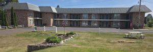 a large brick building with a picnic table in front of it at Budget Host Inn in Ironwood