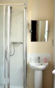 a bathroom with a shower and a sink and a mirror at The Griffin Hotel in Attleborough