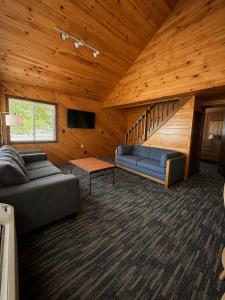 a living room with a couch and a staircase at Depe Dene Lakeside Resort in Lake George