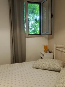 a bedroom with a bed and a window at Casa Dina 2 in Lefkada