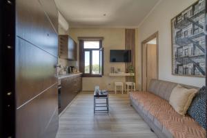 a living room with a couch and a kitchen at Lotza apartment Votsalo in Vrontádos