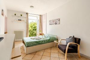 a bedroom with a bed and a chair and a window at Lakeside Paradise Porlezza in Cima +14 photos