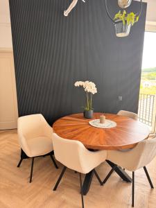 a dining room table with chairs and a table with flowers at Aura Home - Livezeni Hiperbara in Livezeni