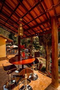 a wooden table and chairs under a wooden roof at Pousada Alto do Vale in Nova Friburgo