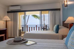 a hotel room with two beds and a balcony at Tango Mar Beachfront Boutique Hotel & Villas in Tambor +58 photos