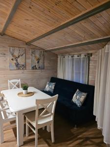 a living room with a table and a couch at Domki w lasku in Wiele