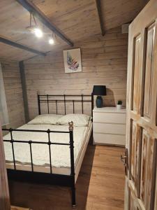 a bedroom with a bed and a wooden wall at Domki w lasku in Wiele