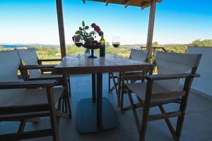 a table with two glasses of wine and a bowl of fruit at Astri Villa in Ierissos