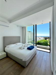 ein Schlafzimmer mit einem großen Bett und einem großen Fenster in der Unterkunft Sunset Park Villas in Paphos City + 50 Fotos