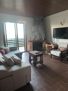 a living room with a couch and a fireplace at Mas Eucaliptus in Susqueda