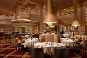 a restaurant with tables and chairs in a room at ITC Grand Chola, a Luxury Collection Hotel, Chennai in Chennai