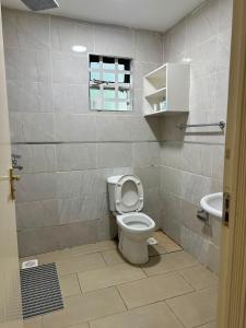 a bathroom with a toilet and a sink at Entebbe Gardens Resort in Kitengela 