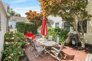 a patio with a table and a red umbrella at Harbor Hideaway in Provincetown