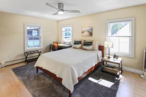 a bedroom with a bed and two windows at Harbor Hideaway in Provincetown