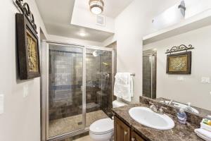 a bathroom with a shower and a toilet and a sink at Salmon Run Condo - Overlooking the Spokane River in Post Falls