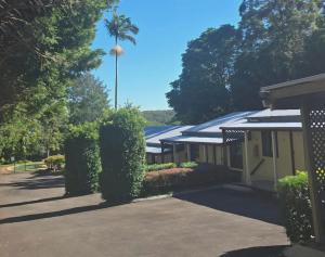 a building with a palm tree in the background at Flaxton Country Lodge in Flaxton