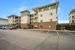 a parking lot in front of a large apartment building at Riverside Condo - Gorgeous Spokane River View in Post Falls