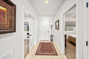 a white hallway with a bed and a rug at Riverside Condo - Gorgeous Spokane River View in Post Falls