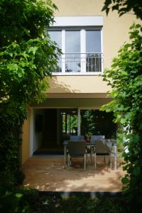 a house with chairs and a table in front of it at City Lake & Peaks Thun in Thun