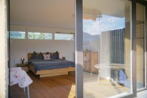 a bedroom with a bed and a table and a window at City Lake & Peaks Thun in Thun