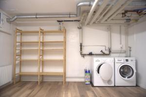 a laundry room with a dryer and a washing machine at City Lake & Peaks Thun in Thun