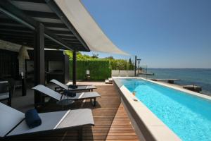 a swimming pool on a building with a view of the ocean at Luxury Feel Good House by the Sea with the Pool in Ždrelac