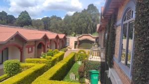 a house with a garden of bushes and trees at Madina Homes in Butare
