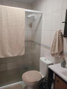 a bathroom with a shower and a toilet and a sink at Aluguel casa azul in Capão da Canoa +13 photos