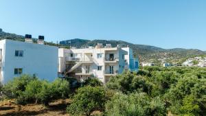 a white apartment building on a hill with trees at Dialinas Apartments in Istro