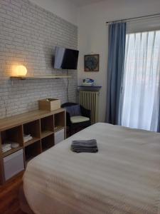 a bedroom with a bed and a tv on a brick wall at La casetta di Elena - Sondrio Valtellina in Sondrio