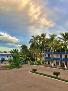 a building with palm trees in front of a parking lot at Hotel York in Guamúchil