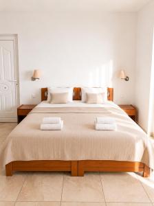 ein Schlafzimmer mit einem großen Bett, auf dem zwei Handtücher liegen in der Unterkunft Evilion studios in Region Ilia + 27 Fotos