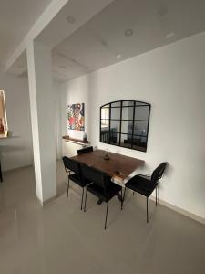 a dining room with a wooden table and black chairs at Appart Yassou in Dar Salah Bey