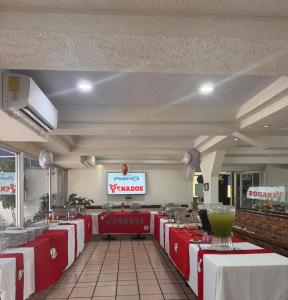 a restaurant with red and white tables and a sign at Hotel York in Guamúchil