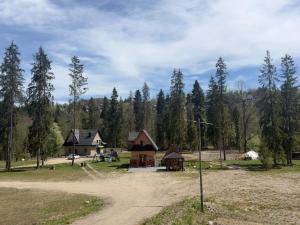 a house in the middle of a field with trees at Camping Przy Termach in Bańska Niżna