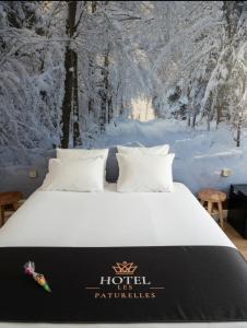 a bed in a room with snow covered trees at Hôtel les Paturelles in Avesnelles