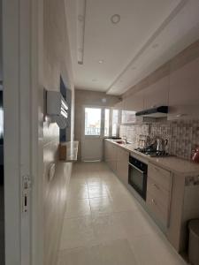 a large kitchen with white cabinets and a stove at Appart Yassou in Dar Salah Bey