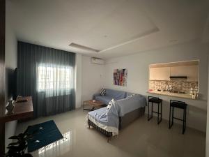 a bedroom with a bed and a table and a kitchen at Appart Yassou in Dar Salah Bey